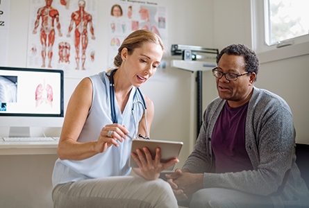 Lungenhochdruck Therapie: Ärztin im Gespräch mit älterem Patienten