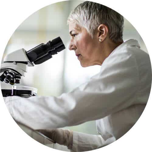 Eine Wissenschaftlerin schaut sich Genmutationen der Retinitis Pigmentosa unter dem Mikroskop an