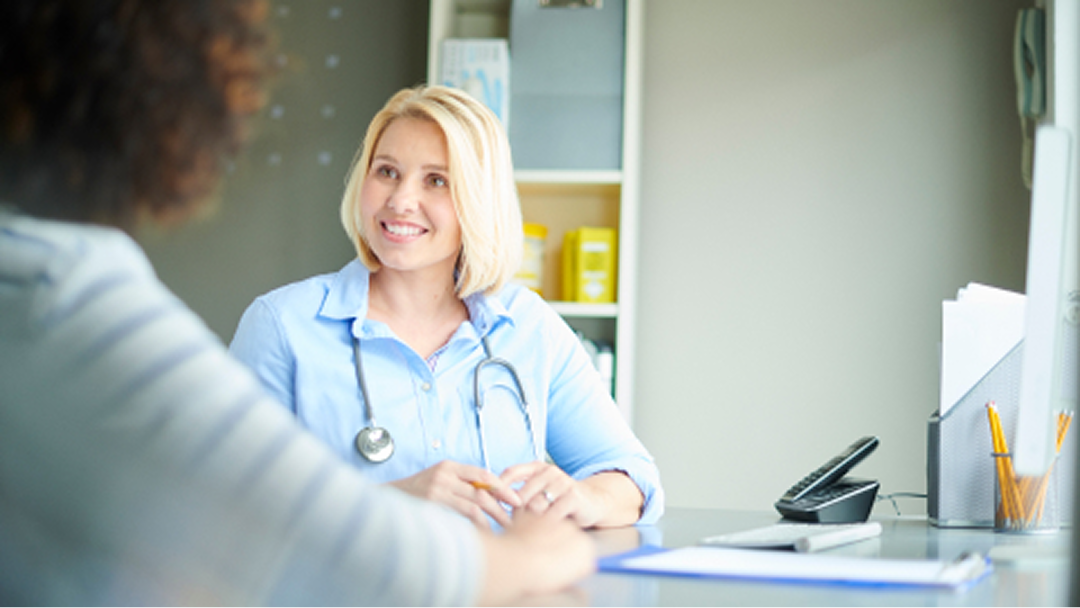 Patientin und Ärztin bei der Aufklärung über mögliche Psoriasis-Behandlungen