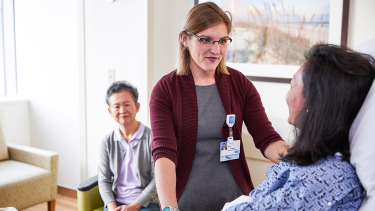 Frau hält die Hand eines an Krebs erkrankten Mannes
