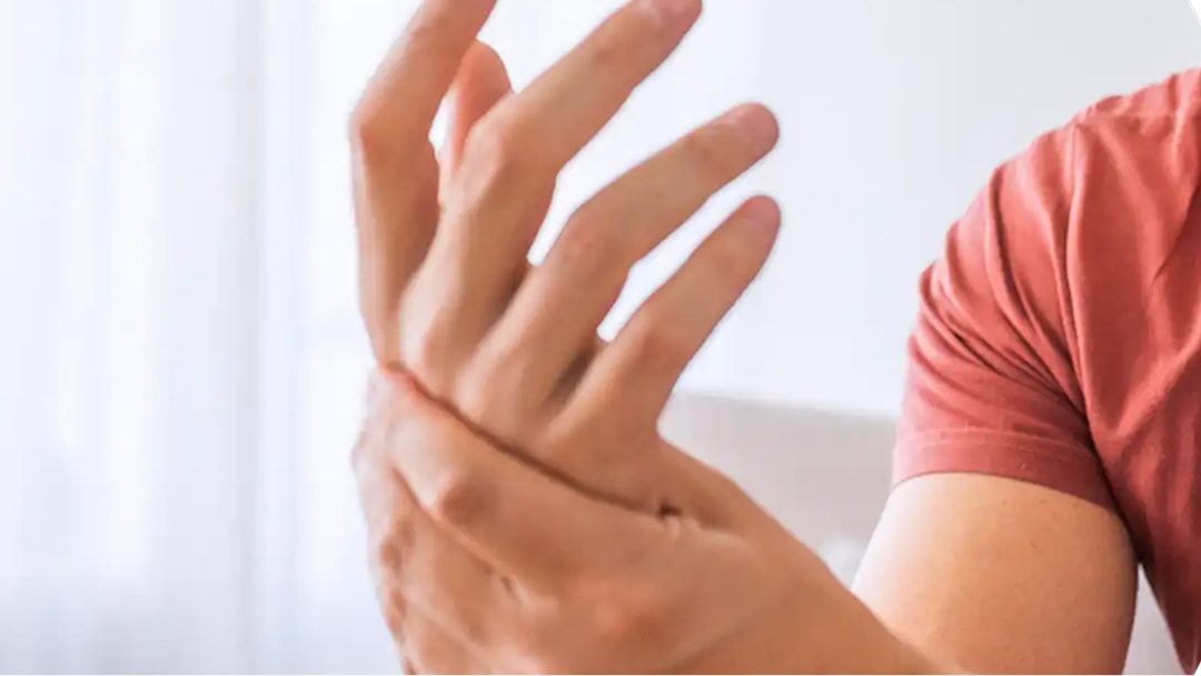 Psoriasis-Arthritis: Mann mittleren Alters hält sich sein schmerzendes Handgelenk