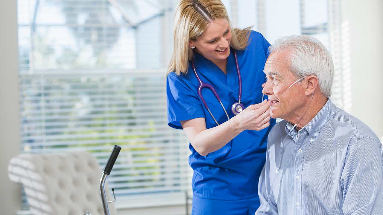 Reisen mit Sauerstoff: Ärztin untersucht älteren Patienten Reisen mit Sauerstoff: Ärztin untersucht älteren Patienten