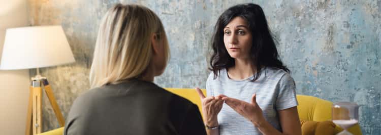 nutzliche-links-fur-betroffene-und-angehorige Eine Patientin mit Depression spricht mit ihrer Therapeutin und nutzt ihre Hände, um dem Gesagten Nachdruck zu verleihen.