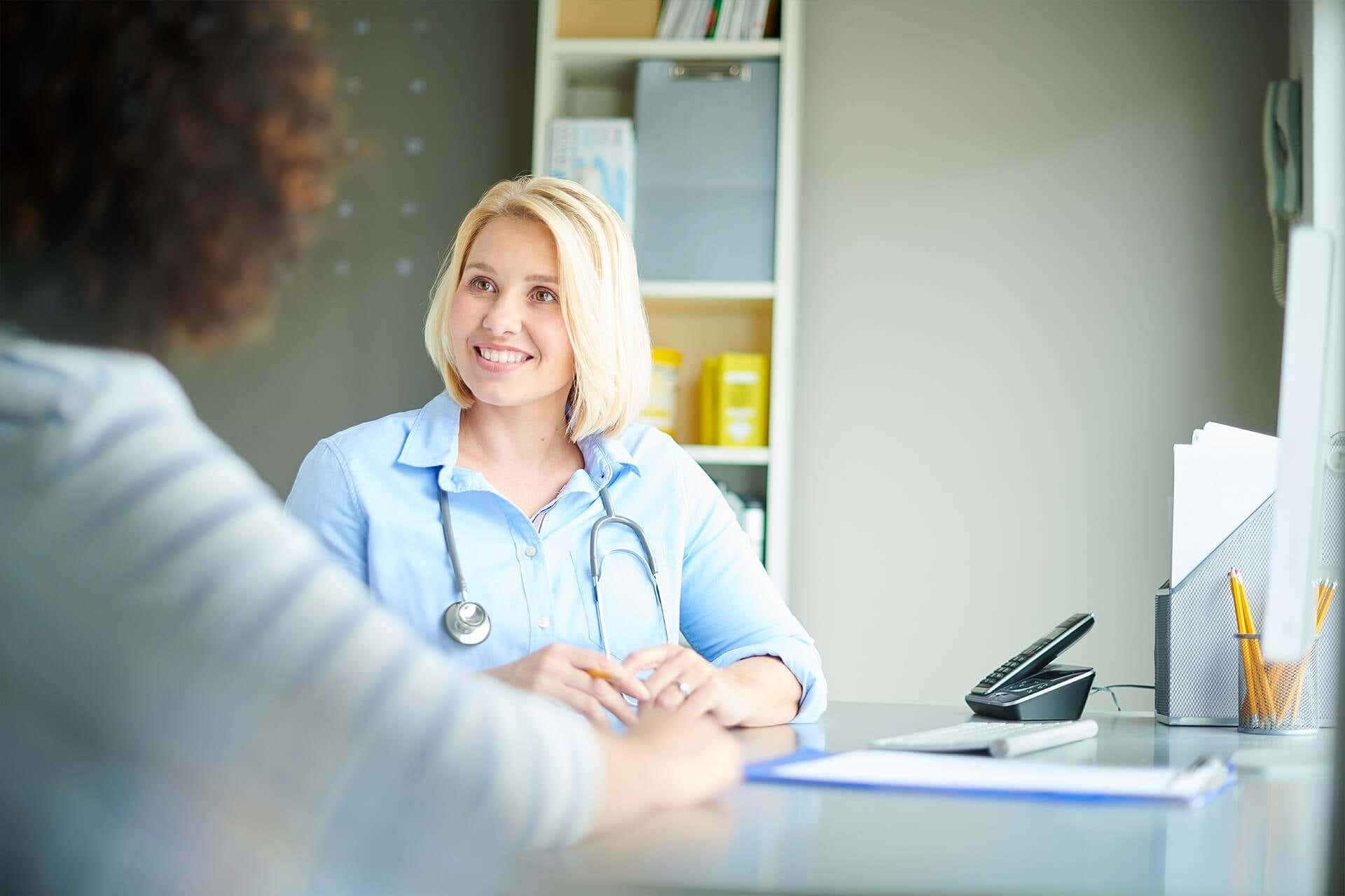 Ärztin berät ein Psoriasis-Arthritis Patient