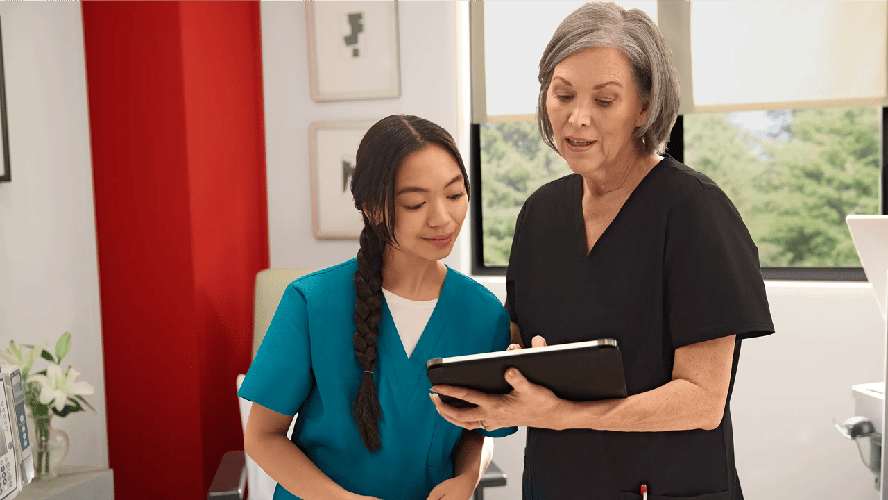 arzt-erklart-patient-lungenkrebs-modell Zwei medizinische Fachkräfte besprechen anhand eines Tablets Informationen zu Lungenkrebs und klären verbreitete Mythen auf.