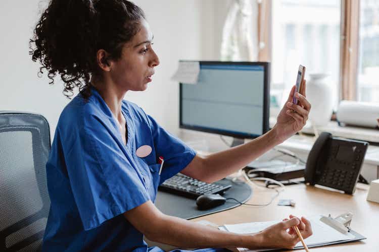 Urlaubsplanung bei Lungenhochdruck medizinisch abklären: Ärztin am Schreibtisch telefoniert Urlaubsplanung bei Lungenhochdruck medizinisch abklären: Ärztin am Schreibtisch telefoniert
