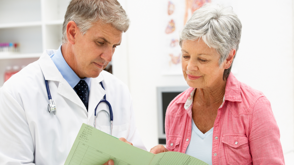 Onkologe bespricht mit einer älteren Patientin mit Lungenkrebs die gemeinsame Therapieentscheidung.