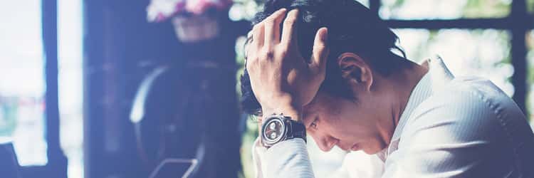 depression-besser-verstehen-header Mann stützt deprimiert den Kopf auf den Händen ab. Symbolbild für die Erkrankung Depression.