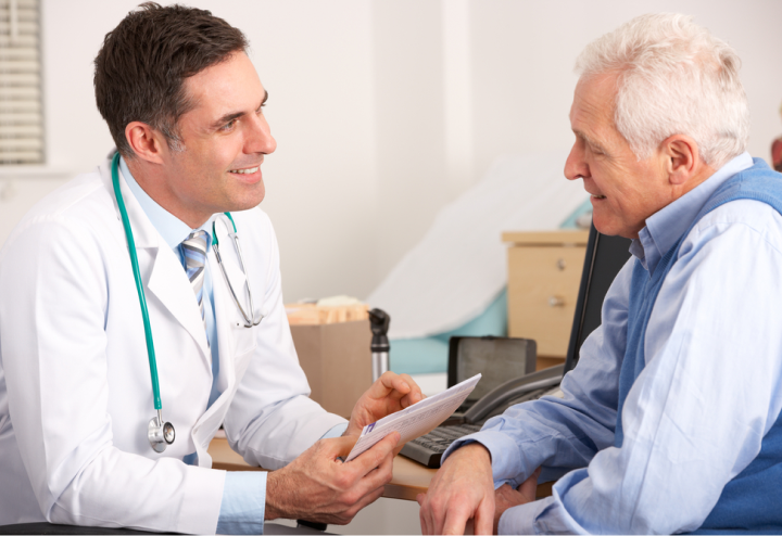 Arzt führt Gespräch mit älterem Patienten.