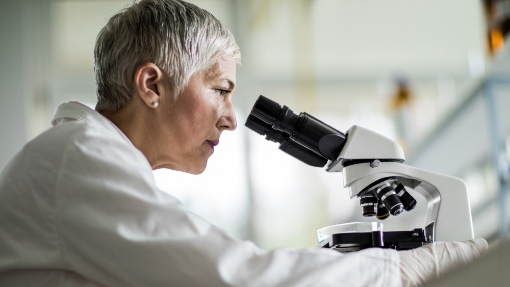 Eine Wissenschaftlerin schaut sich Genmutationen der Retinitis Pigmentosa unter dem Mikroskop an