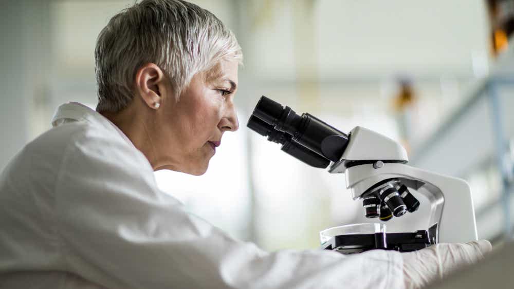 Eine Wissenschaftlerin schaut sich Genmutationen der Retinitis Pigmentosa unter dem Mikroskop an