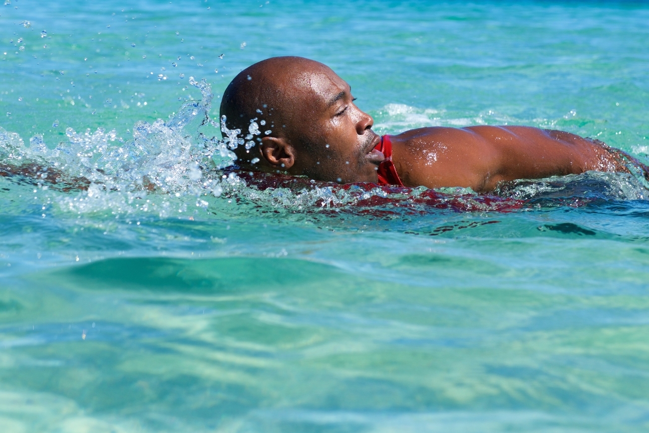 A man swimming in the ocean with his head above water, enjoying a peaceful moment of relaxation.
