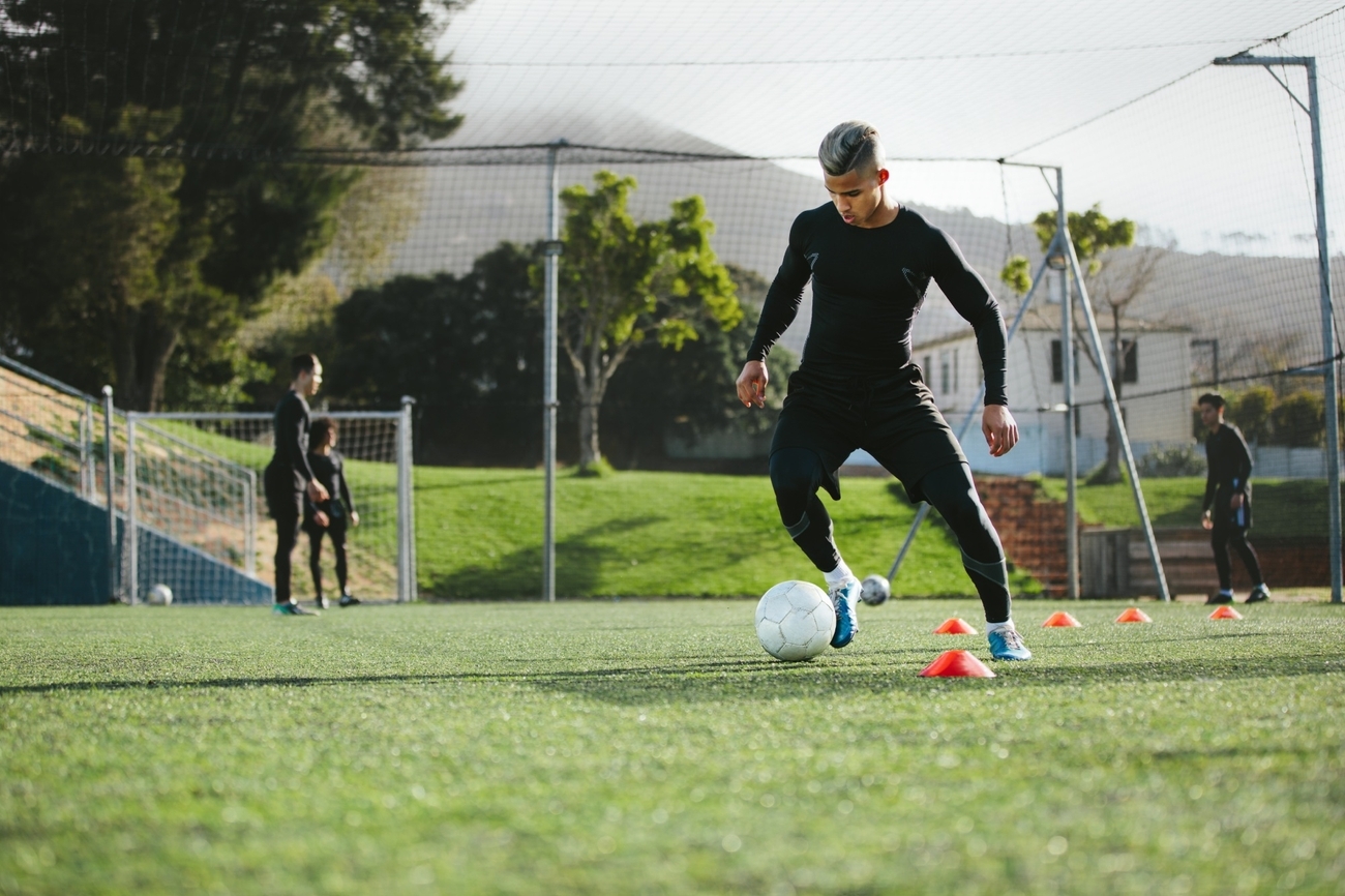 Soccer player practicing on grass field.