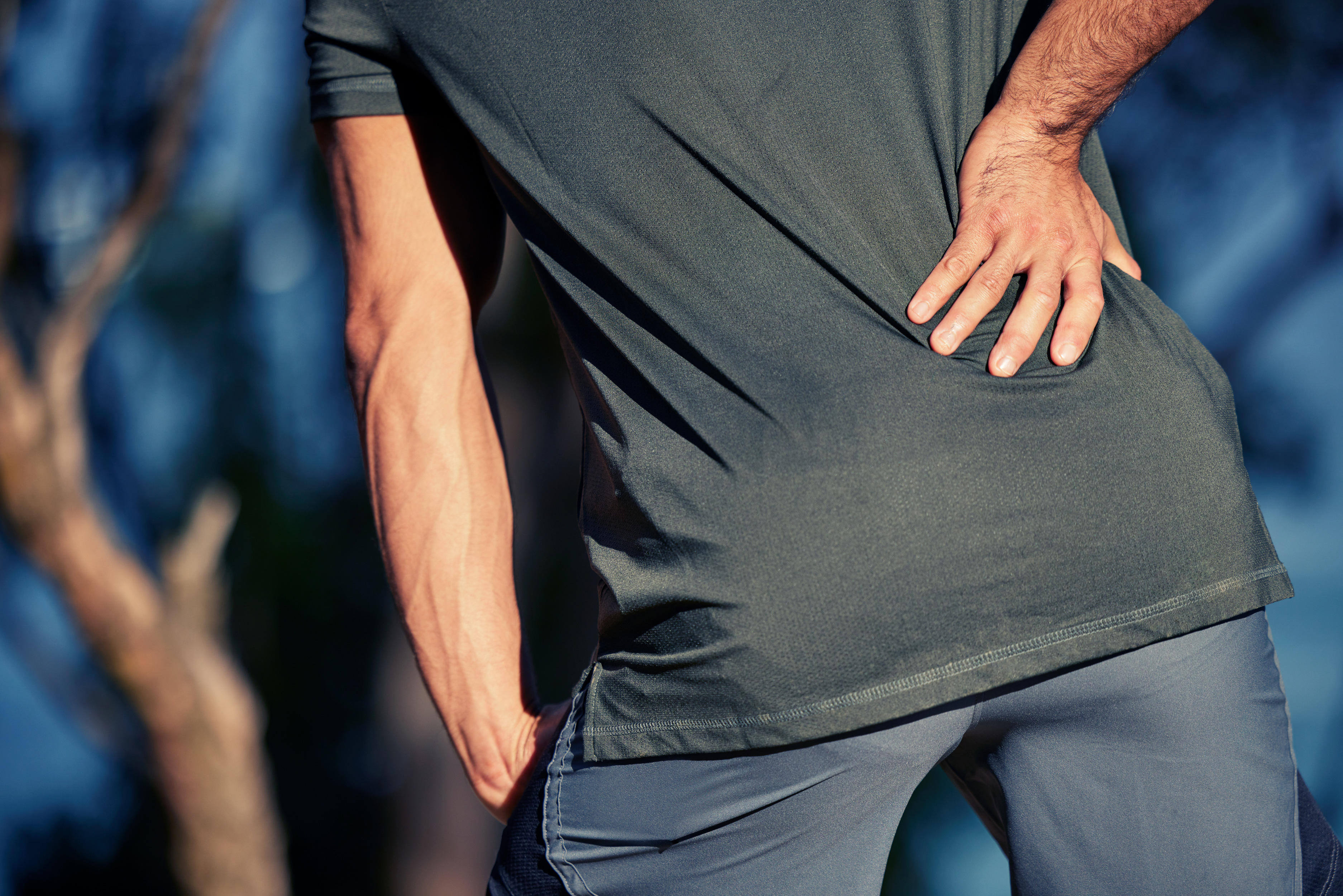 Man suffering lower back pain while holding his back