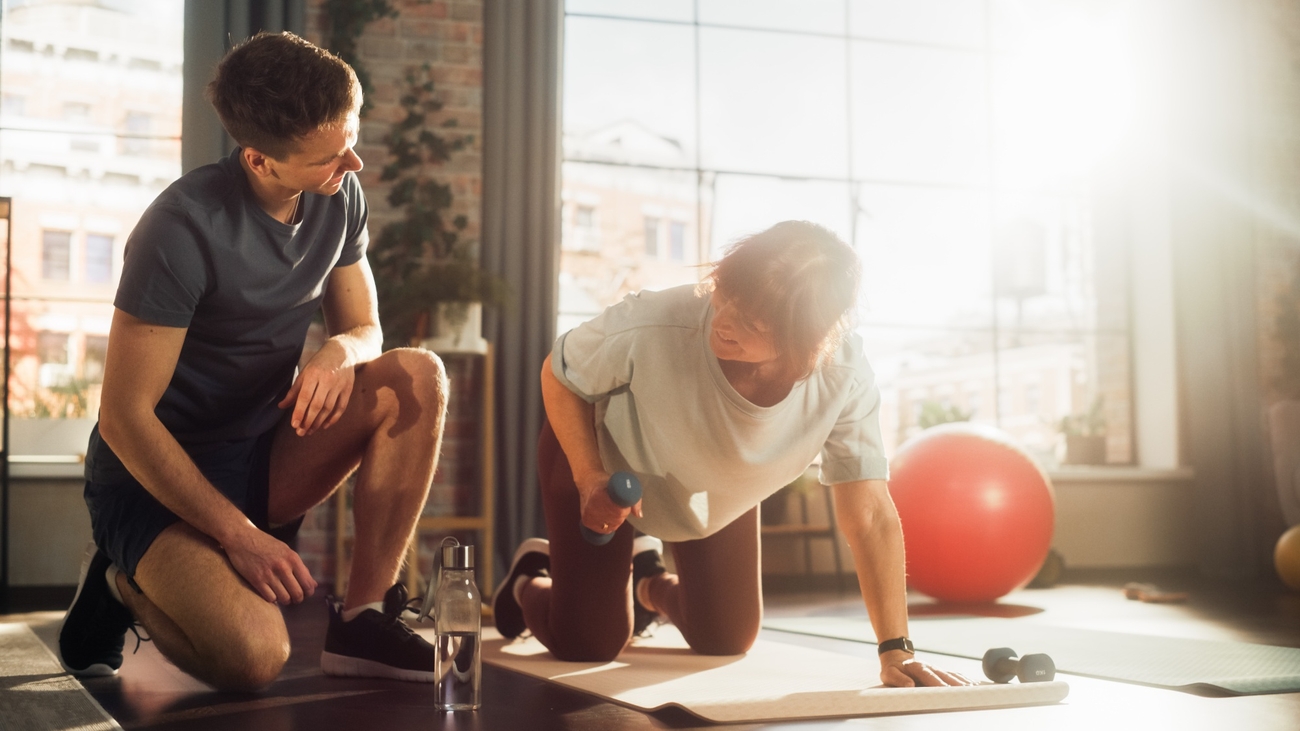 Two men exercising with dumbbells in a gym.