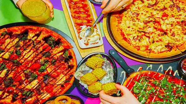 Pizza Hut friends sharing a selection of pizzas and sides
