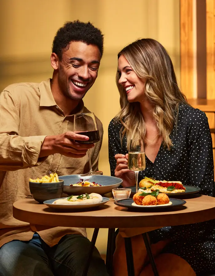 Man and woman on a date drinking wine and laughing