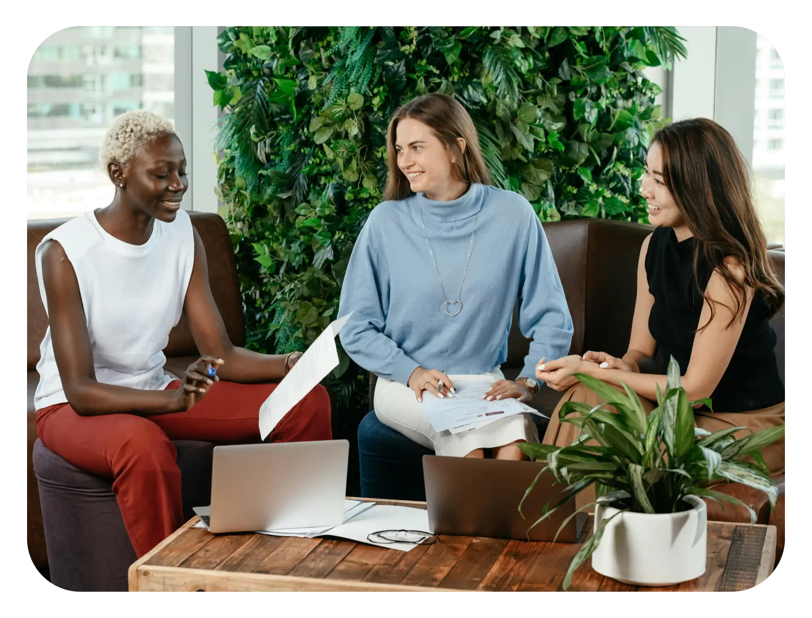 People discussing business with paperwork and a laptop