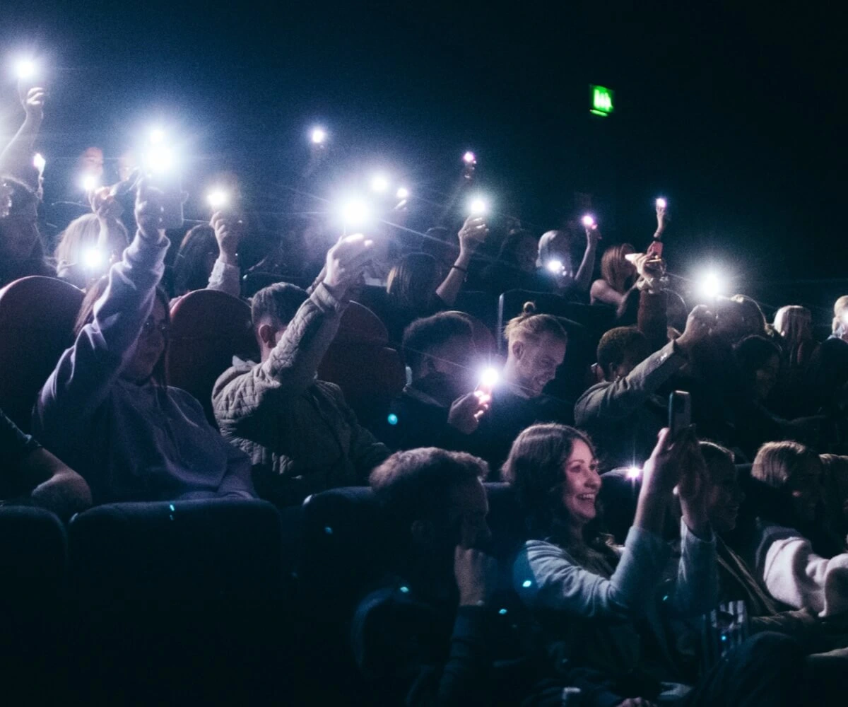 Crowd holding up torches on phones 