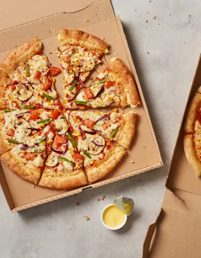 Slices of a vegetarian pizza in a pizza box