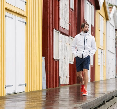 Kille på brygga med regnjacka och shorts från Helly Hansen