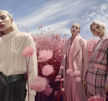 Three women with short blonde hair and pink shaded clothes in a pink flower field by Marc Cain.