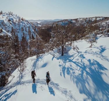 Varg AW25 – två personer vandrar på snötäckt bergsrygg i Varg outdoor-kläder.