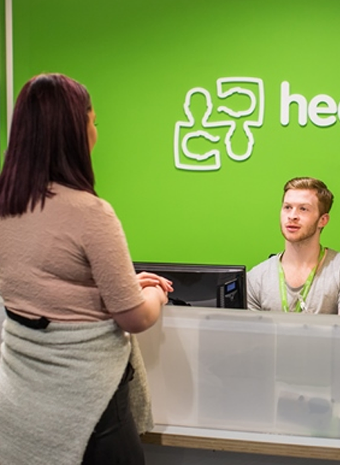 A customer speaking with a staff member at a service desk
