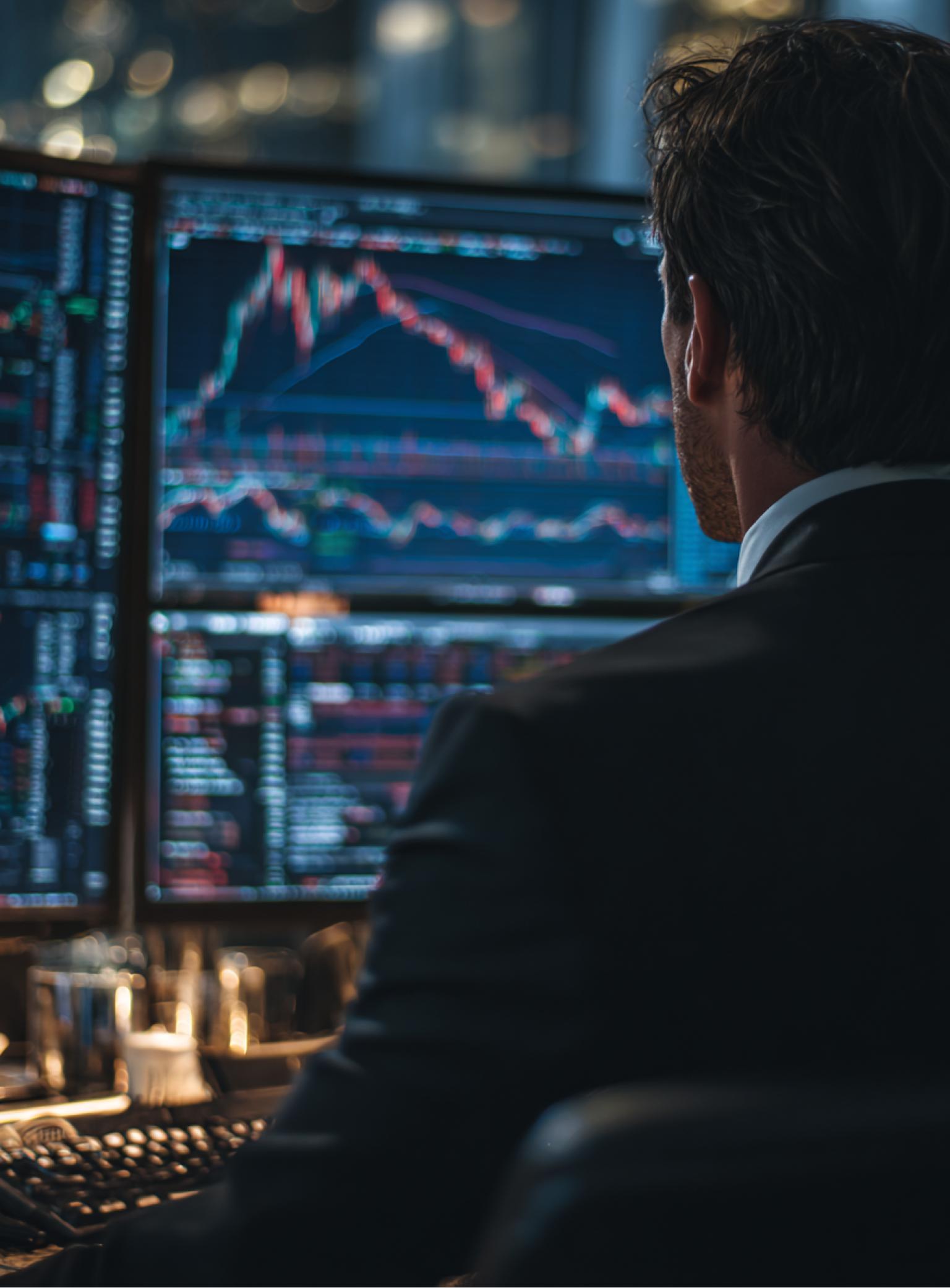 A trader monitoring multiple screens displaying financial charts
