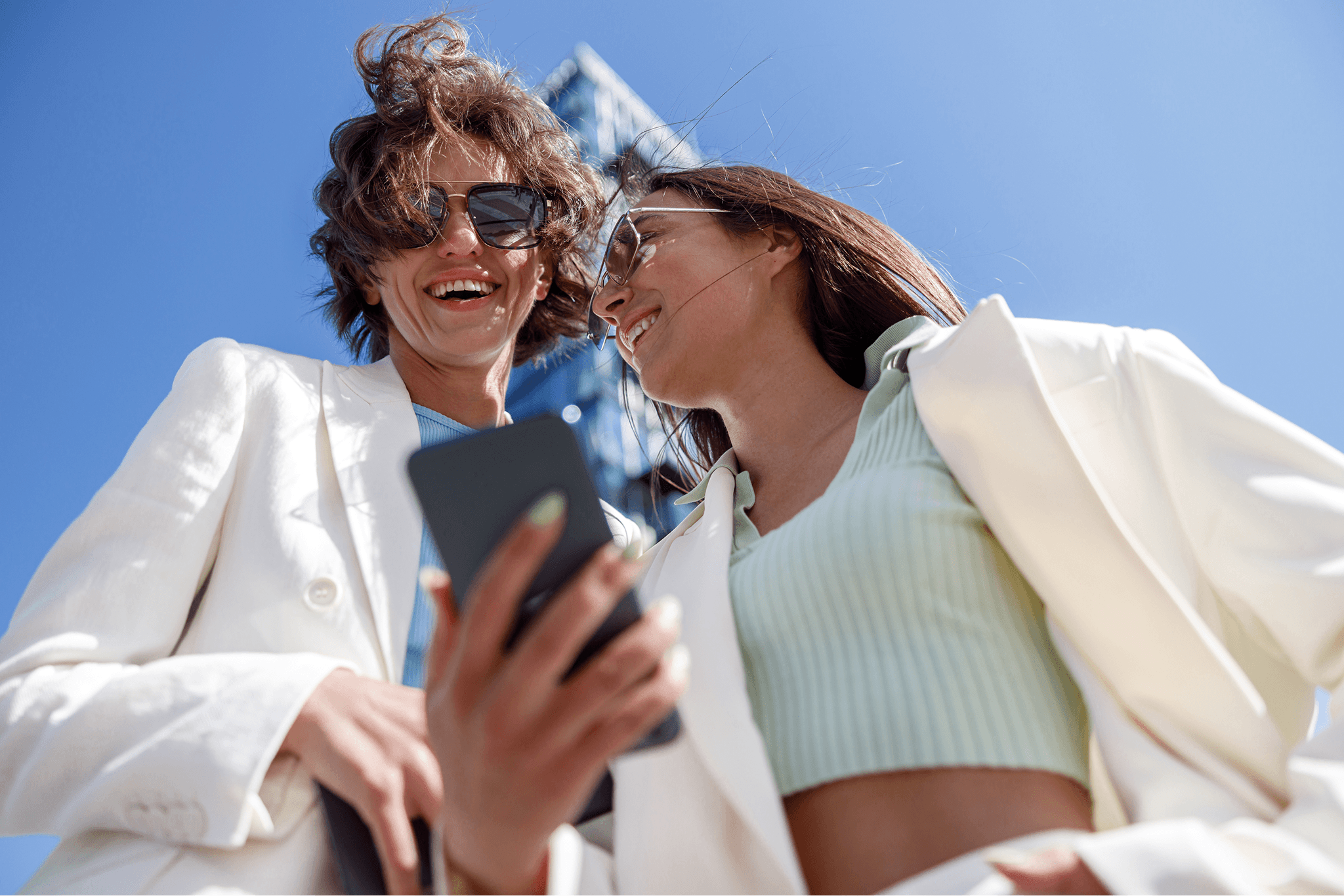 smiling-female-friends-in-trendy-outfits-use-phone-2026-01-08-08-01-40-utc_1.png