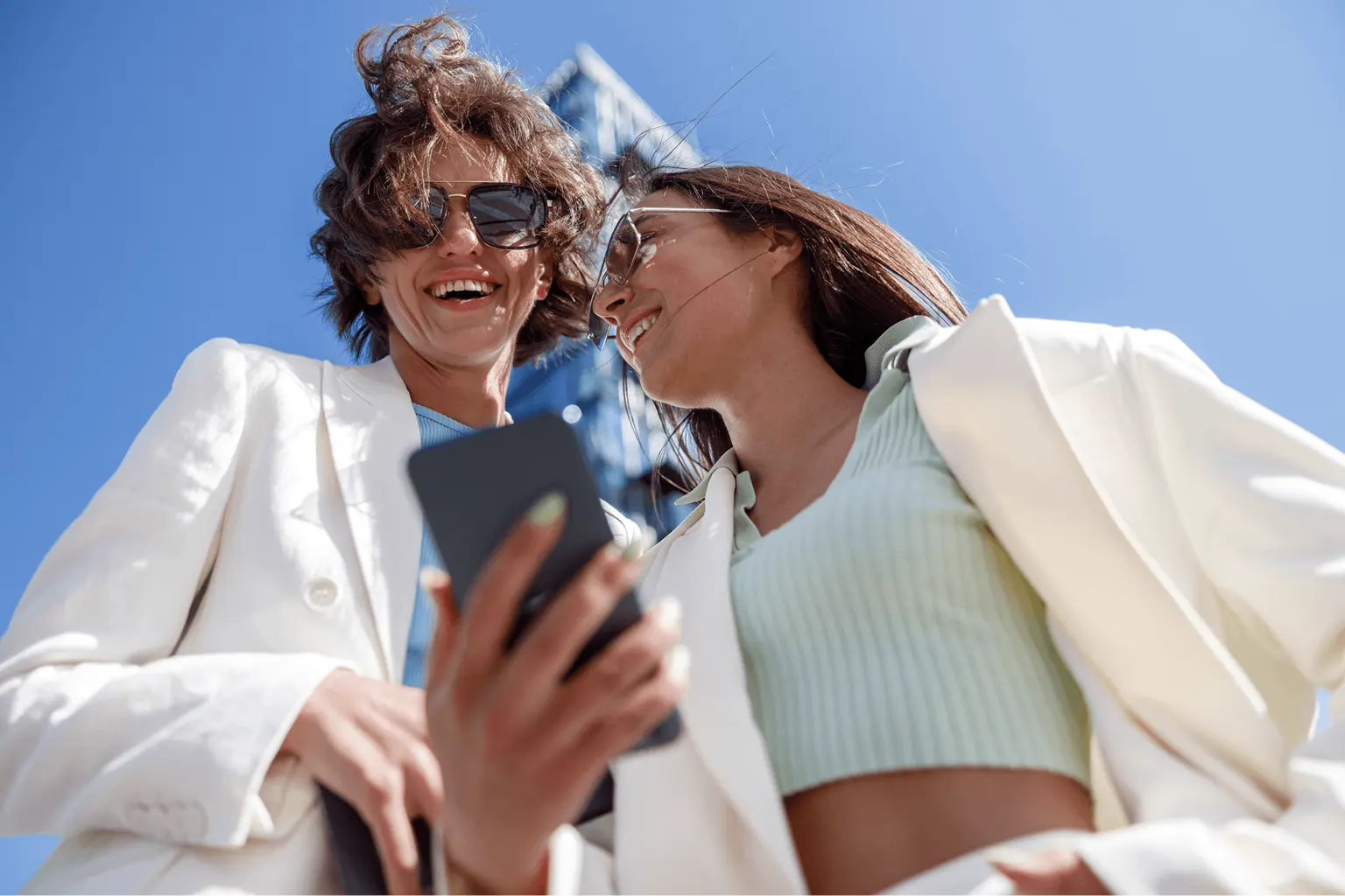 smiling-female-friends-in-trendy-outfits-use-phone-2026-01-08-08-01-40-utc_1.png