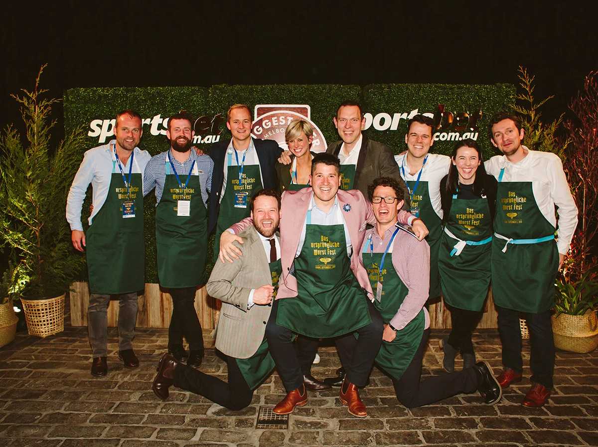 Group photo of people wearing green aprons at a corporate event