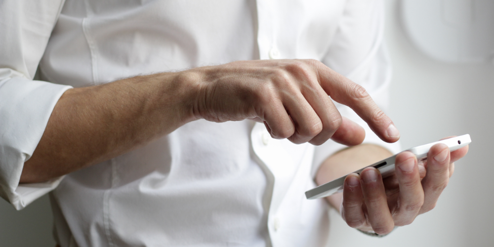 Man tapping on his phone's touchscreen