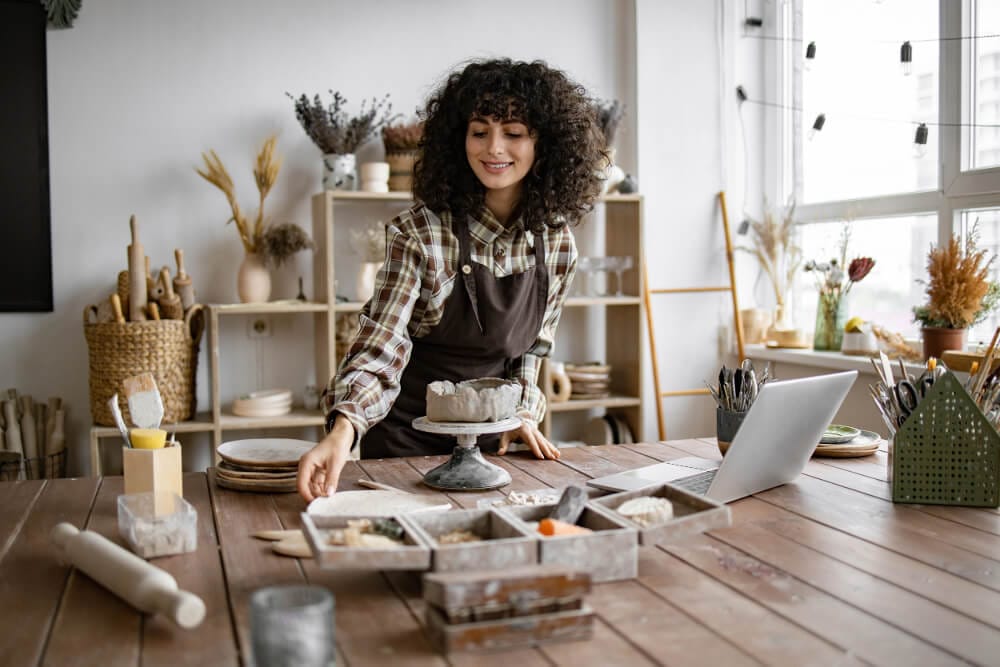 a woman building clay bowls and pots in her studio