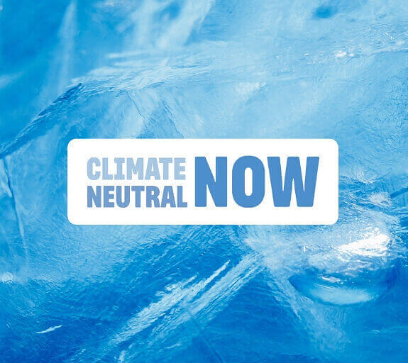 A Climate Neutral Now logo on a background image of an iceberg