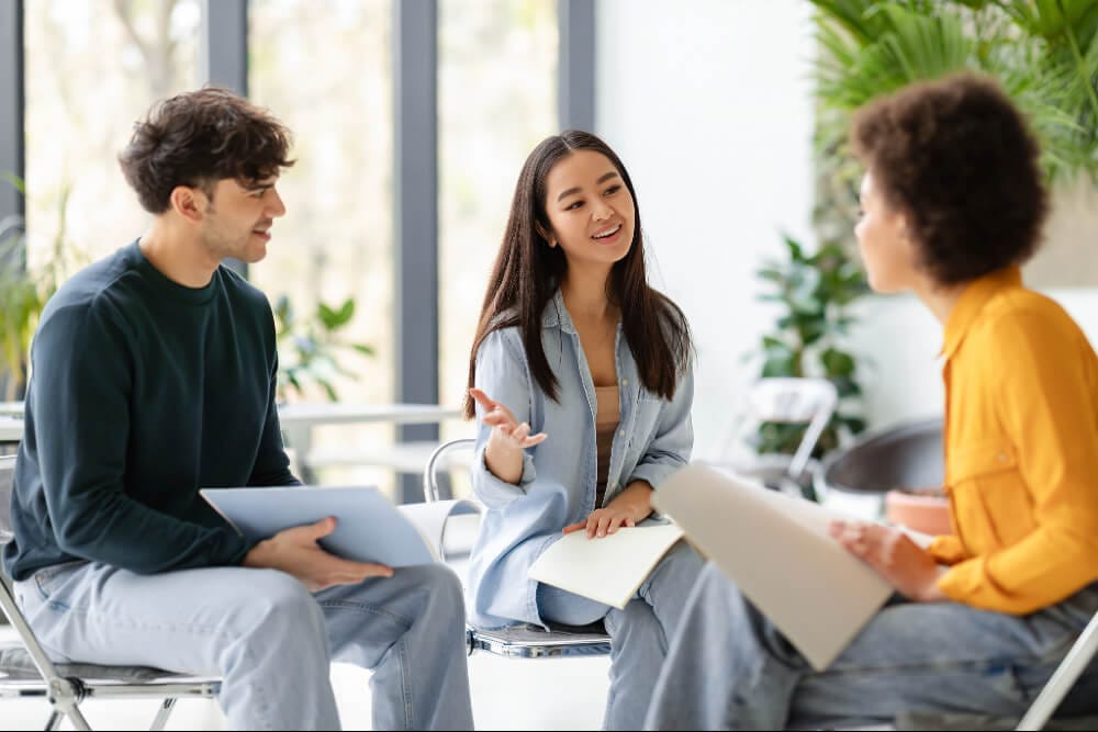 Three students talking together in a group