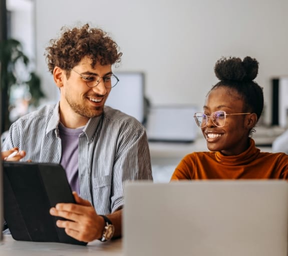 man and woman working on laptops