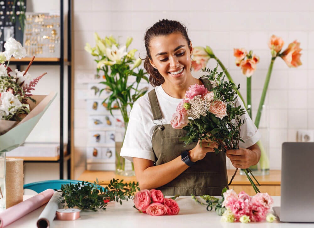 A woman standing and preparing some flowers