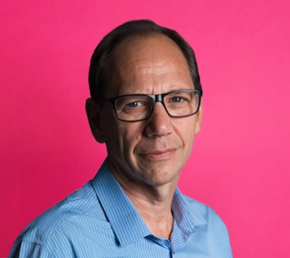 Headshot of Lee Rochford with a pink background