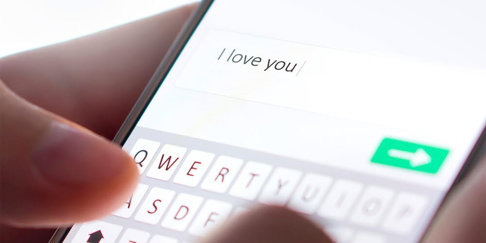 Zoomed in image of a phone with someone texting the words I love you just before sending