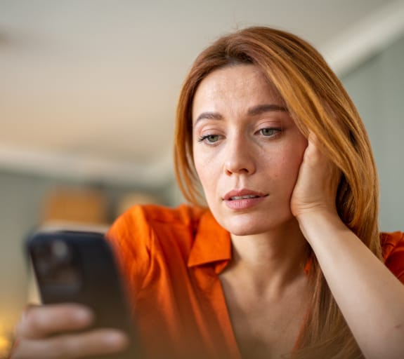 Woman leaning on her hand and looking at her phone