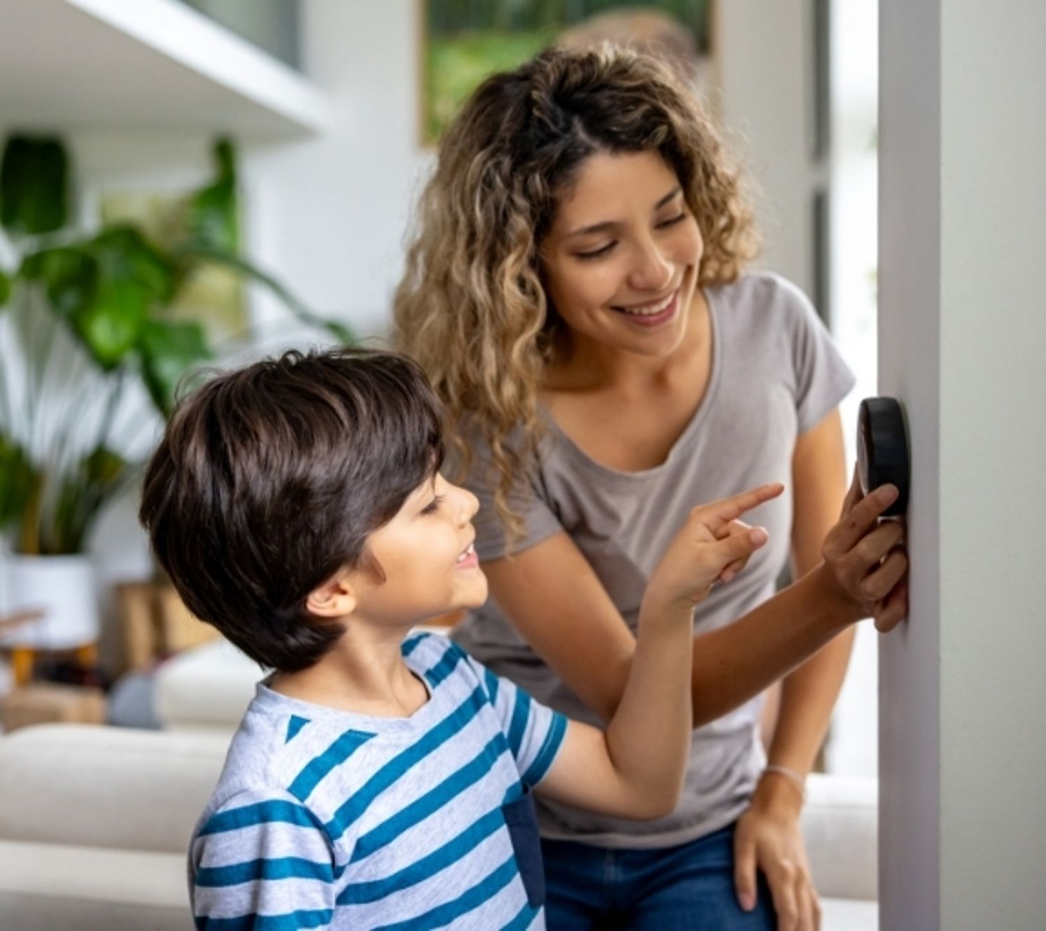 Mother and son adjust home's thermostat