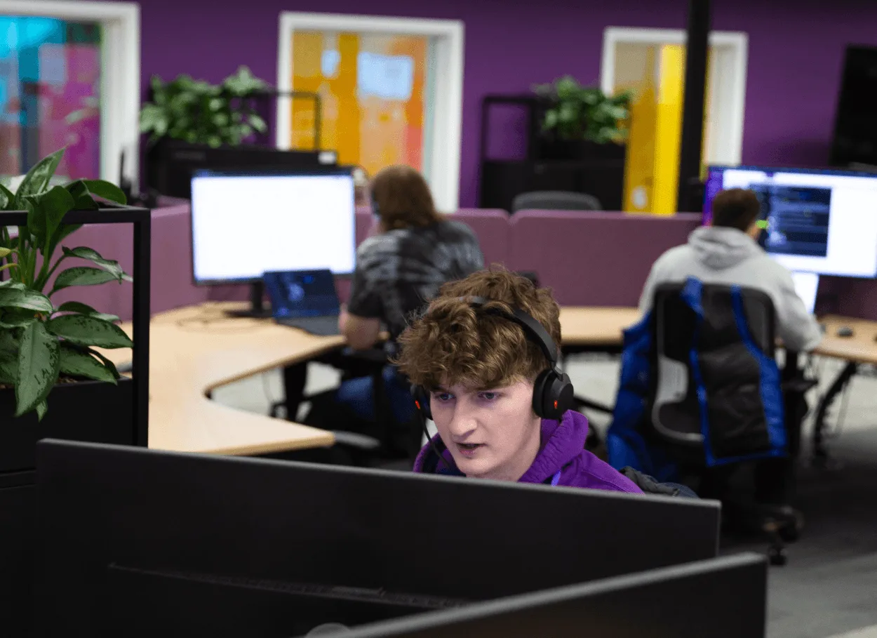 A man working at a desk with headphones in an office