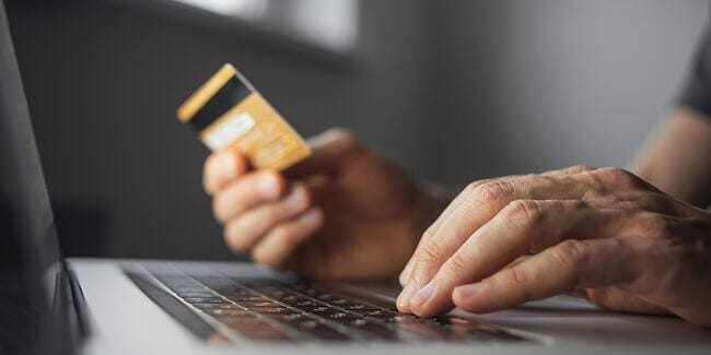 A person shopping online with their credit card