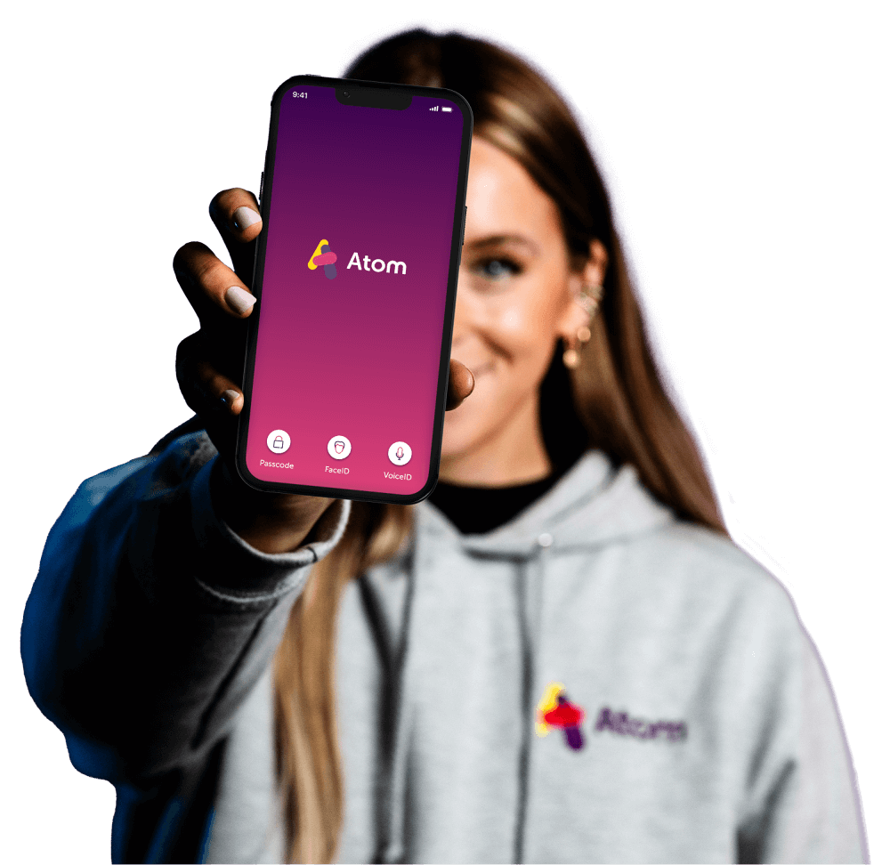 A woman holding a phone out showing the atom app homepage