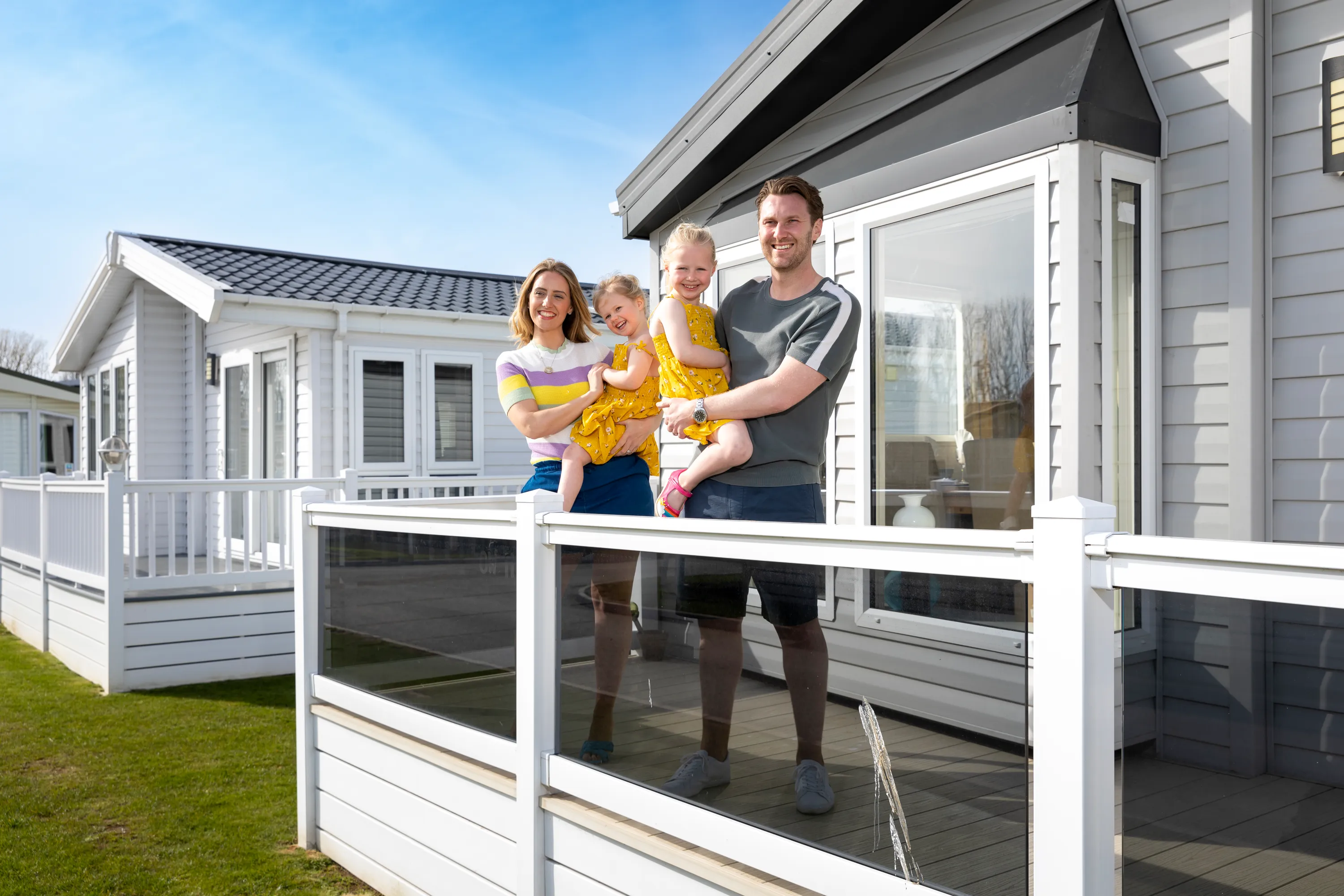 DAT-2022_Suffolk_Felixstowe_Beach_ParkFamily_young_family_girls_looking_out_lodge_decking_ (4).webp