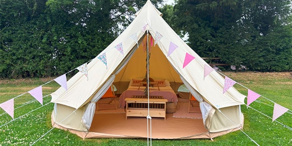 A bell tent with a freshly made double bed