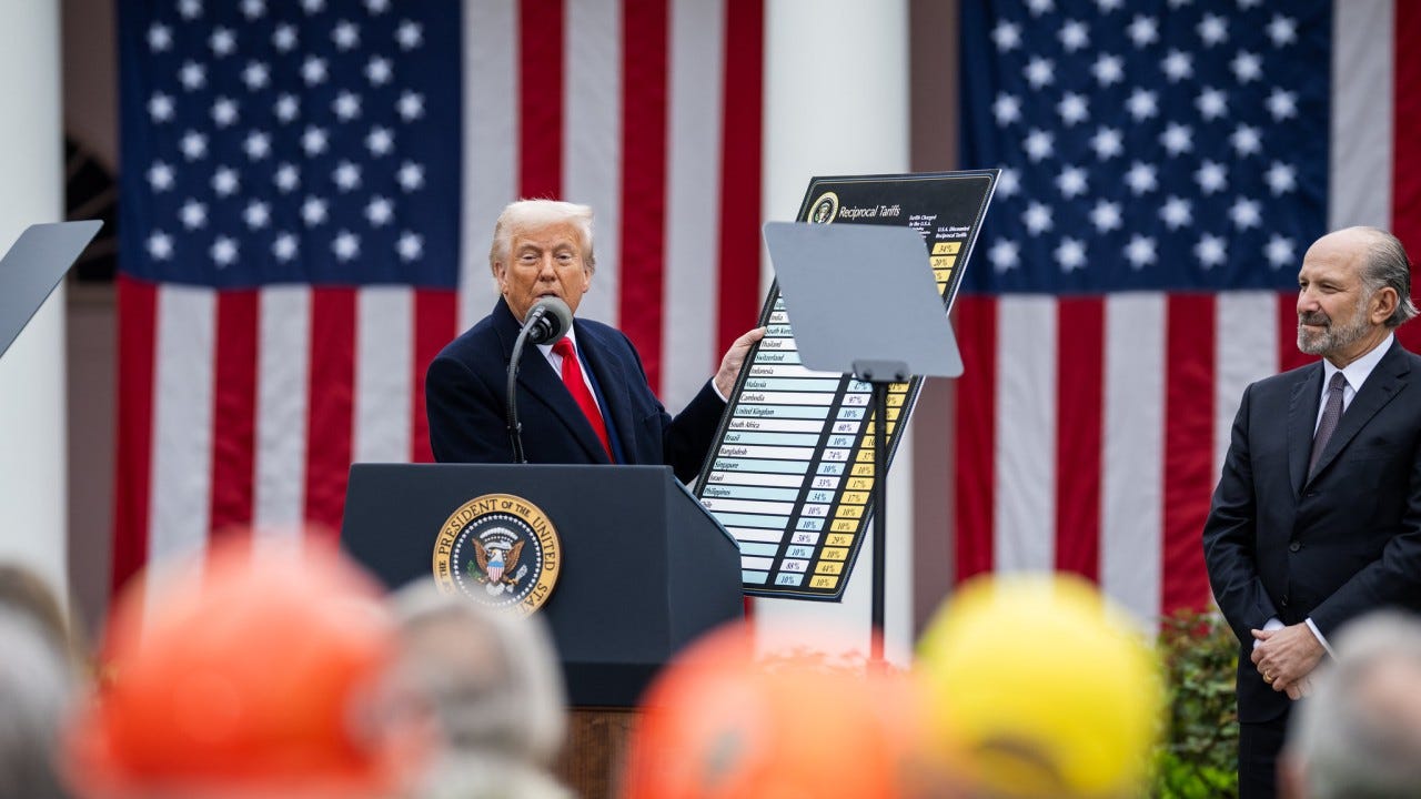 Man with white board in front of US flags
