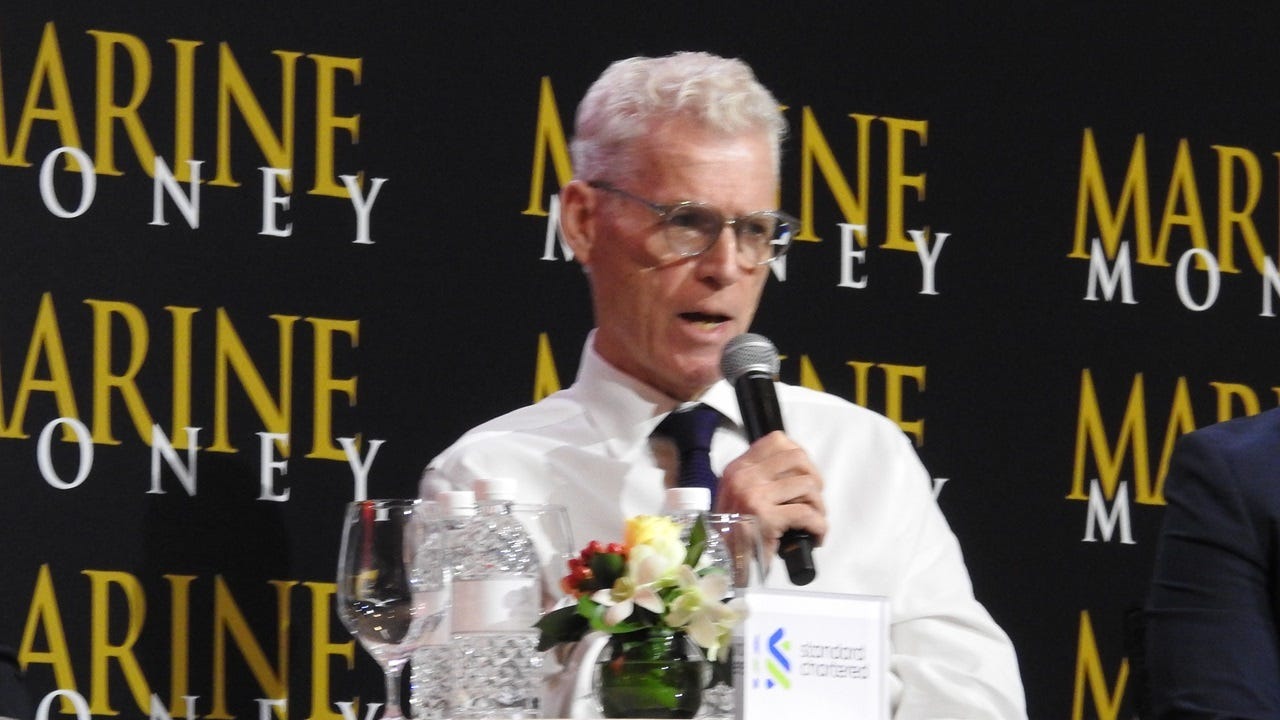 Man in white shirt speaking into microphone