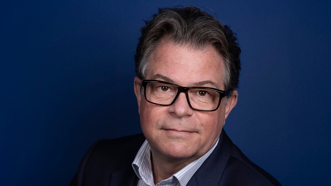 Man in glasses wearing dark suit 